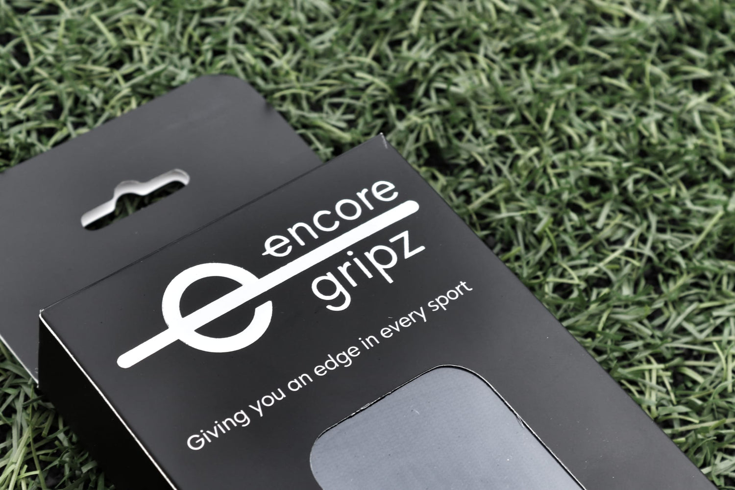 the packaging box for encore non-slip grip socks on a football field background