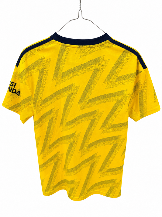 Yellow short-sleeve soccer jersey with a dark navy patterned zigzag design, hanging on a metal hanger against a white background.